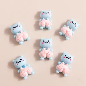 Flat lay of six cute resin blue cat charms for DIY phone case decoration crafts