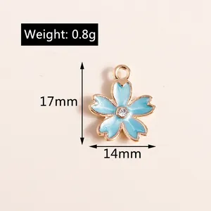 Macro shot of 17x14mm sky blue enamel cherry blossom pendant with golden edges and gem