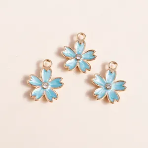 Detailed view of light blue cherry blossom enamel pendants with gold edges and crystals