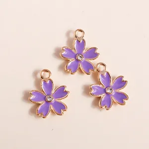 Three purple cherry blossom flower pendants with gold plating and center rhinestone