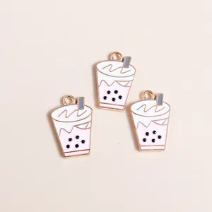 Dettaglio di ciondoli smaltati bubble tea rosa con bordi dorati e schiuma bianca