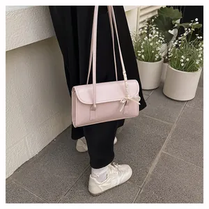 Pink shoulder bag detail showing the elegant white silk bow on the slim leather strap