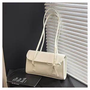 Detailed view of the off-white leather shoulder bag with a bow accent and woven finish