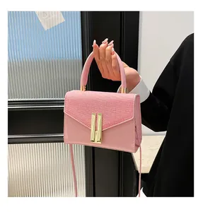 Détail du sac à main rose avec rabat tissé et fermoir à boucle dorée en forme de H