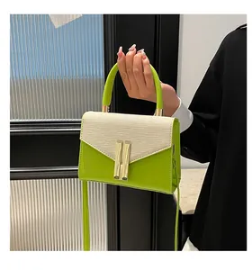 Détail du sac bandoulière vert citron et beige avec boucle dorée et texture tissée