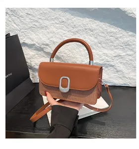 Detail of the woven texture and smooth leather flap on this stylish top handle bag
