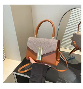 Detail of color-block flap bag with woven texture and gold magnetic clasp closure
