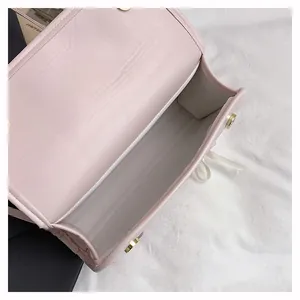 Top view of the light pink handbag showing spacious single main compartment and magnetic clasp