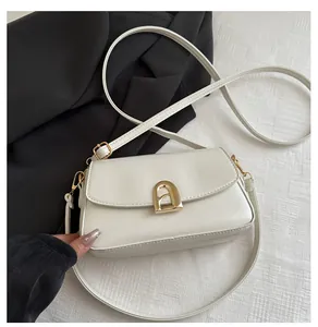 Macro detail of cream leather shoulder bag with golden A-shaped metal clasp closure