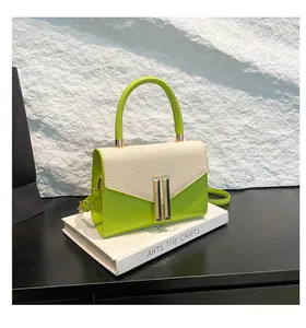 Detail of green leather and woven fabric tote bag with elegant gold metal lock