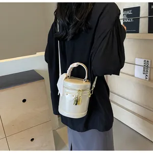 Rear view of cream bucket bag with silk scarf detail and shoulder strap on model