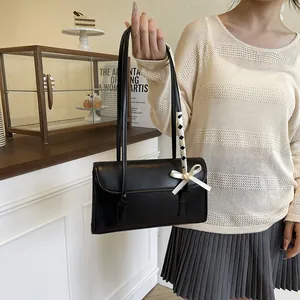Elegant black leather shoulder bag with white bow knot and woven strap detail