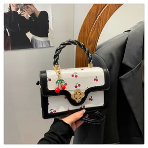 Détail du sac blanc à imprimé cerise avec fermoir fleur et breloque cerise en 3D
