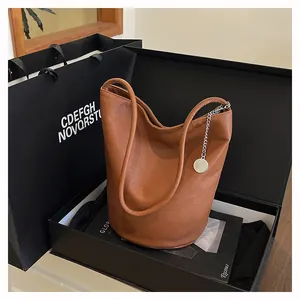 Detailed view of brown leather bucket bag with silver chain in a premium gift box set