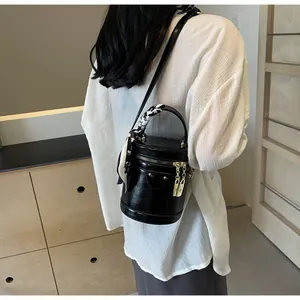 Detailed back view of a black glossy leather bucket bag with a stylish printed silk scarf