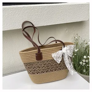 Detail der Strohtasche mit Kontrast-Ledergriffen und weißem Spitzenbogen-Accessoire