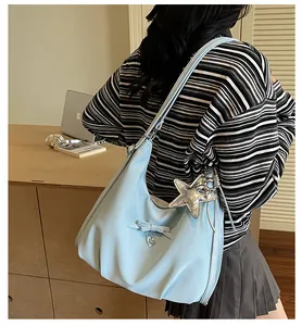 Detail of light blue hobo bag with ribbon bows and sparkling silver star pendant