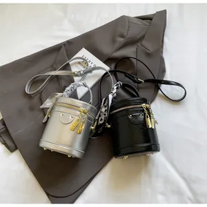Detail of stylish bucket bags with decorative silk scarves and golden hardware accents