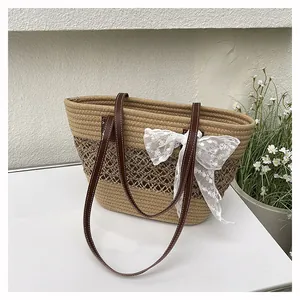 Detail der handgewebten Stroh-Tote-Bag mit Spitzenschleife und Ledergriffen