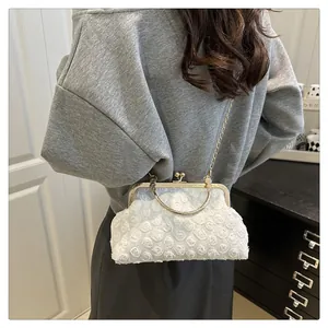Detailed texture of white rose petal fabric on vintage evening bag with gold metal frame