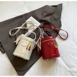 Close-up of bucket bags with silk scarf handles, gold chain decor and leather texture