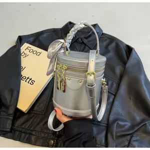 Detail of silver bucket bag with silk scarf handle, gold zippers and metallic rivets