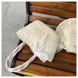 Detalle de bolsa de paja y sombrero de sol con lazo de encaje y rayas de colores