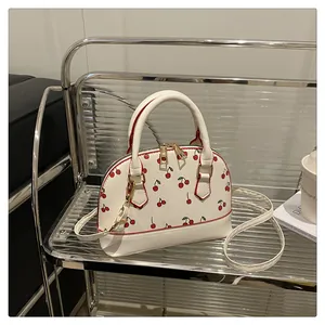Detailansicht der weißen Muscheltasche mit Kirschdruck auf einem Taschenständer