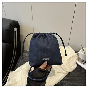 Dettaglio ravvicinato della borsa a secchiello in denim blu con logo JINGPIN in metallo