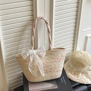 Bolso saco de paja con bordados coloridos y un lazo de encaje blanco elegante