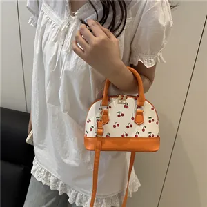 Frische Muscheltasche mit Kirschprint, orangefarbenem Rand und verstellbarem Schultergurt