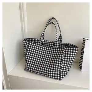 Gros plan sur la texture du motif à carreaux d'un sac cabas minimaliste avec anses
