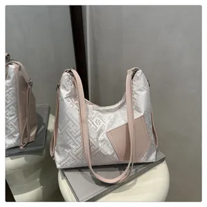 Detailansicht von weißem Jacquard-Stoff mit traditionellen Mustern und rosa Lederbesatz