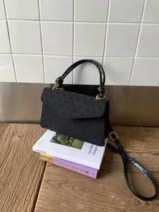 Détail du sac à main noir à pois en tissu avec boucle dorée et bandoulière élégante