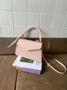 Détail du sac à bandoulière rose clair avec broderie cœur et garnitures dorées