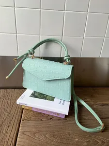 Vue détaillée du sac à main vert menthe avec texture gaufrée et poignée nouée élégante