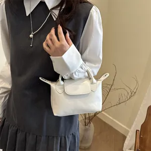 Petit sac à main blanc minimaliste en cuir porté en bandoulière avec un collier de perles