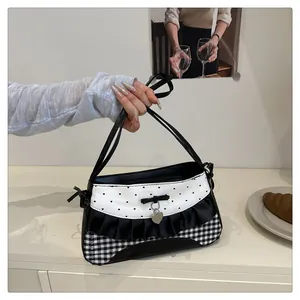 Detail of contrast bow shoulder bag featuring heart charms and ruffled hem design