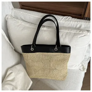 Detail shot of summer woven tote bag with black faux leather trim and metallic rings