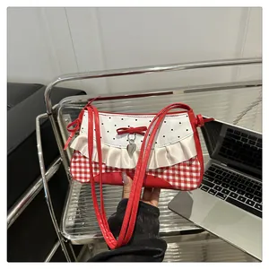 Detail der rot-weiß karierten Handtasche mit Schleife, Herzanhänger und Rüschen
