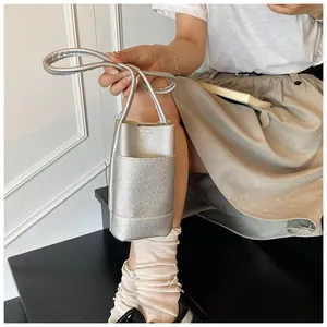 Detail of silver bucket bag showing textured lychee leather and stylish vertical design