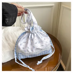 Detail of floral and checkered bucket bag with lace trim and drawstring closure