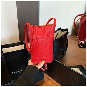 Detailed macro view of the red lychee pattern leather and front pocket of the bucket bag