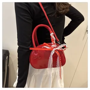 Detail of red patent leather handbag with lace bow decoration and detachable strap