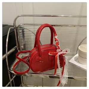 Detail of red glossy patent leather bowling bag with red and white lace bow handles