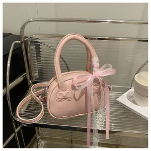 Detailed view of pink handbag with embossed bows and lace ribbon on metallic stand