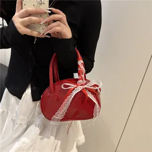 Elegant red heart-shaped handbag with silk scarf and lace bow on glossy leather material