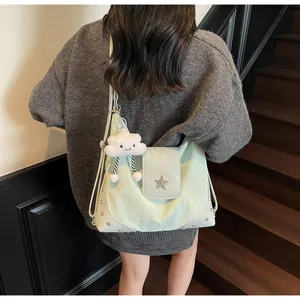 Detail of mint green nylon bag with silver star emblem and cute cloud plush charm