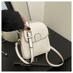 Detail of white PU leather mini bag with double zippers and adjustable strap