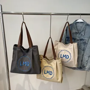 Canvas tote bags in grey and khaki with leather handles and letter embroidery